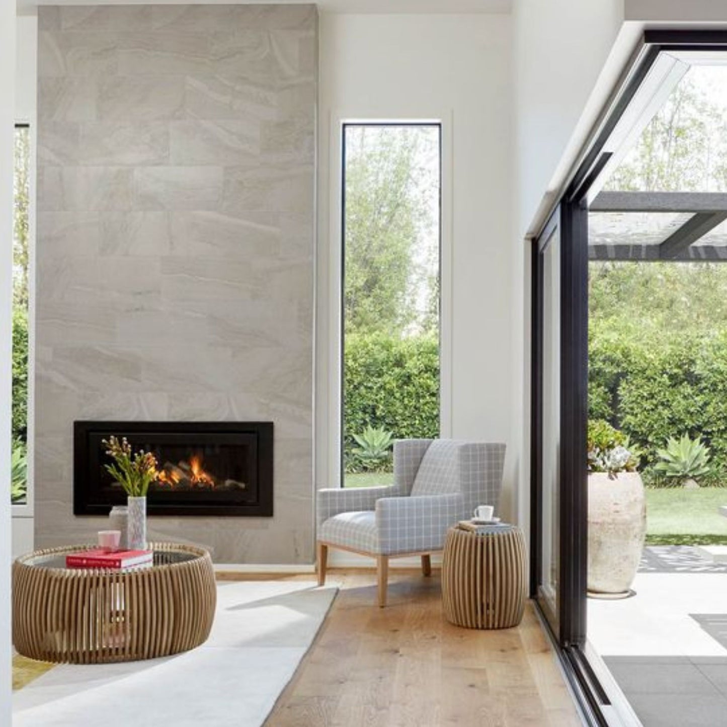 Obzidan kaminski vložek z ravno zasteklitvijo, obzidava je obložena z sivimi keramičnimi ploščicami