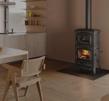 Wood-burning stove in a modern kitchen with wooden chairs and a window.