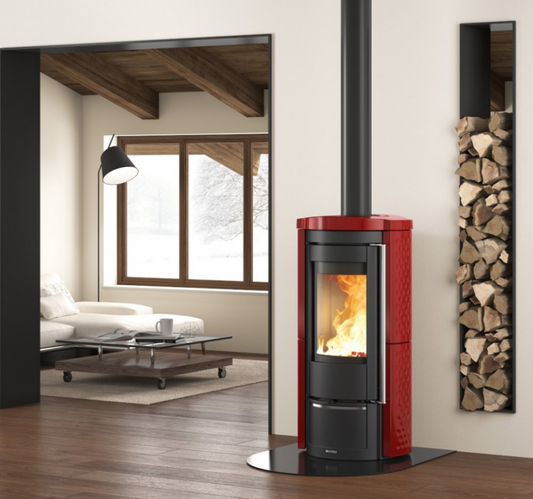 Red and black freestanding stove in a modern living room with a view of another room.